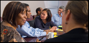 People sitting around a table talking and listening.