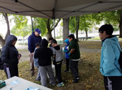 Students inspect water collected from the Mystic River near Blessing of the Bay Boathouse.