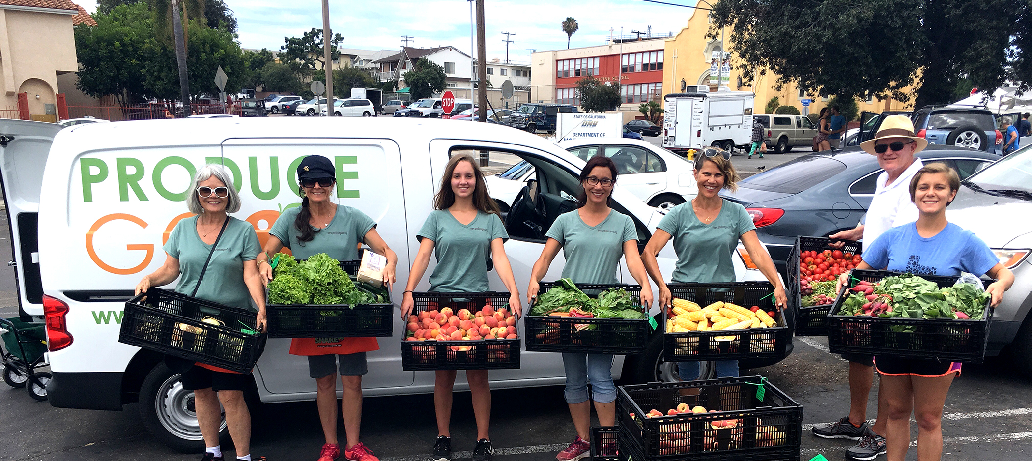 This is a picture of a group of people holding a variety of vegetables.