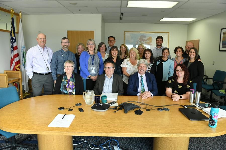 Wheeler and staff gathered aroudn a large conference room table