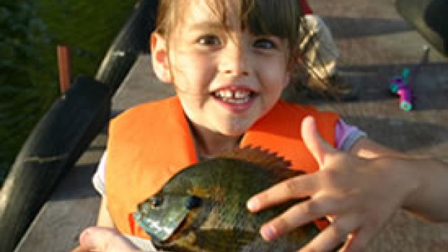 Presenting a fish to a little girl 