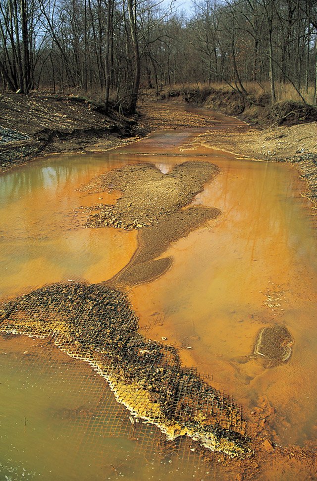 Iron hydroxide precipitate (orange) in a Missouri stream receiving acid drainage from surface coal mining.