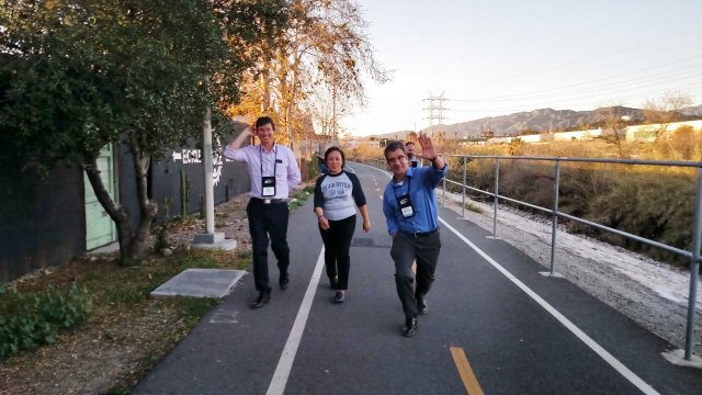 Conference participants walk a bike trail along the Los Angeles River. 