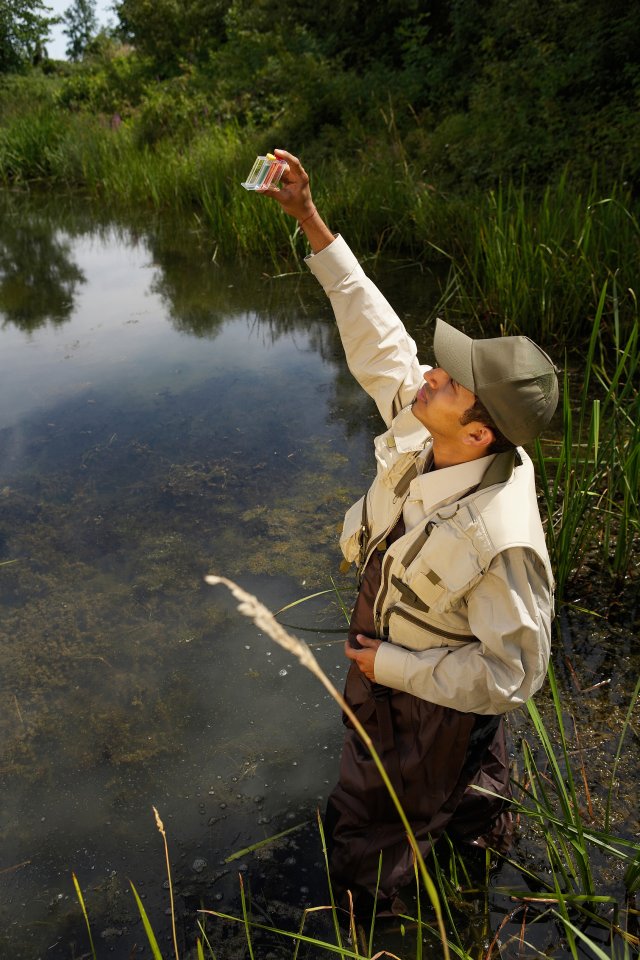 Man holding up water test to the sun light.