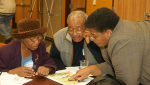 a woman showing an older man and woman something on a map  