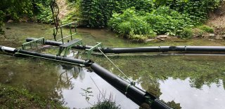 Installation of a Bandalong Trash Trap in Proctor Creek, GA. Photo courtesy of Groundwork Atlanta.