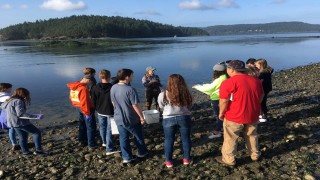 Citizen scientists huddled together next to a waterbody