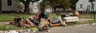 Trash illegally dumped in front of a residence.