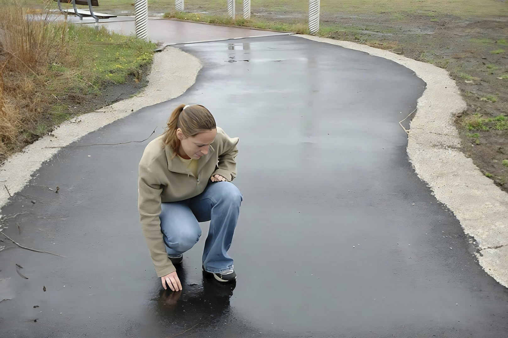 Person bending down to touch permeable pavement