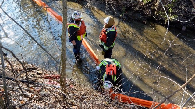 Crews set boom in Sulphur Run to prepare for culvert cleanout operations