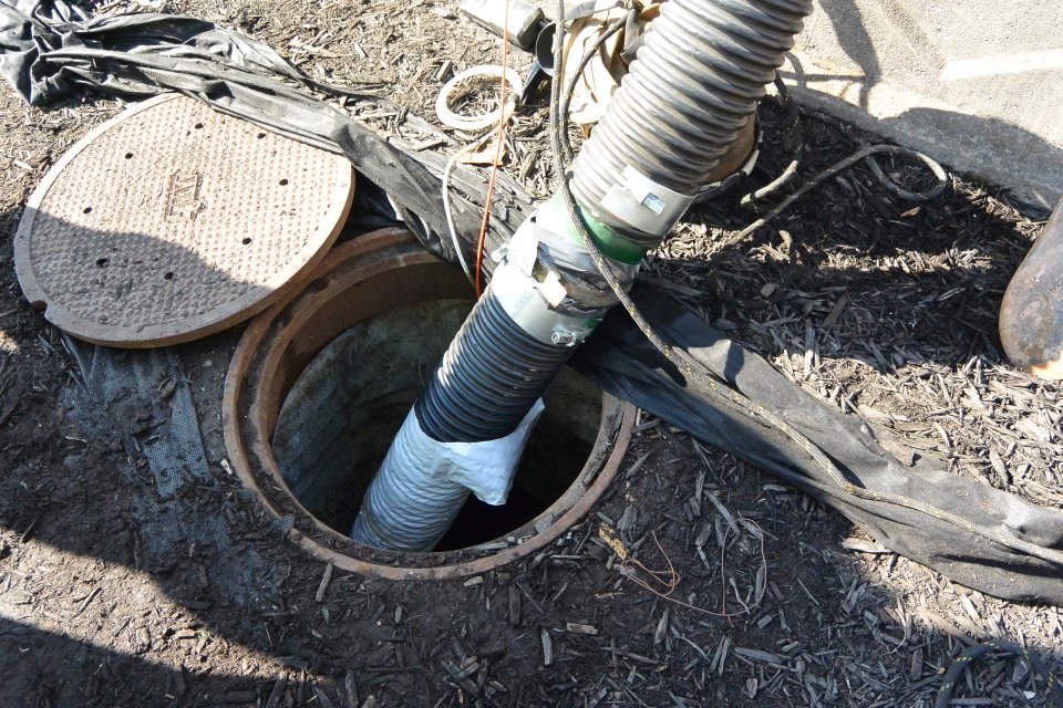 Vacuum trucks pull sediment out of a culvert