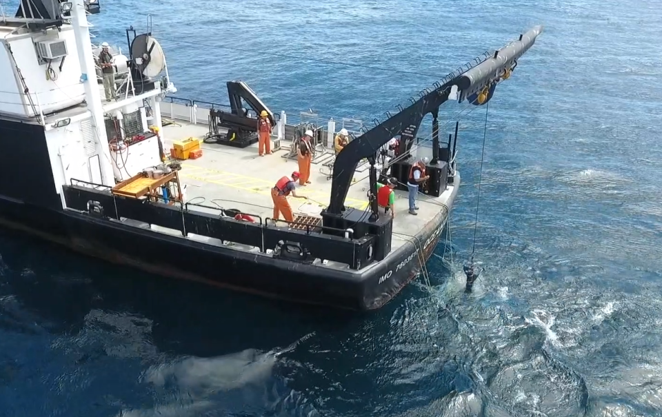 Oceanographic technician deploying equipment using an A frame.