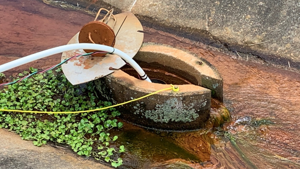 A white tube pumping water into a relief well.