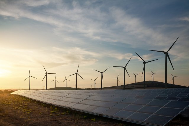 solar wind farm in front of a setting sun