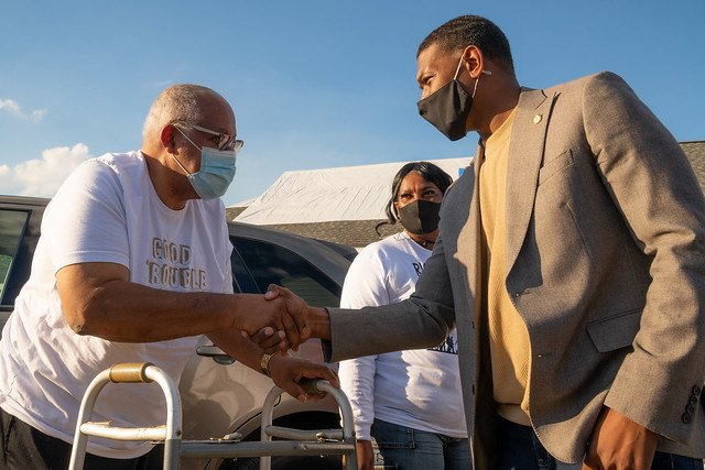 Administrator shakes hand with St. James citizens