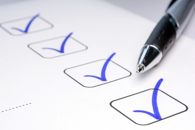 pen next to four boxes with blue check marks in them.