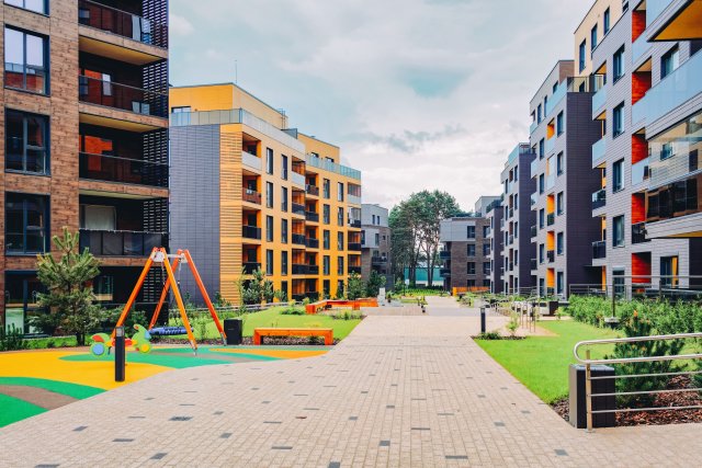 Multifamily buildings in the background, with sidewalks, playgrounds and green space in the foreground