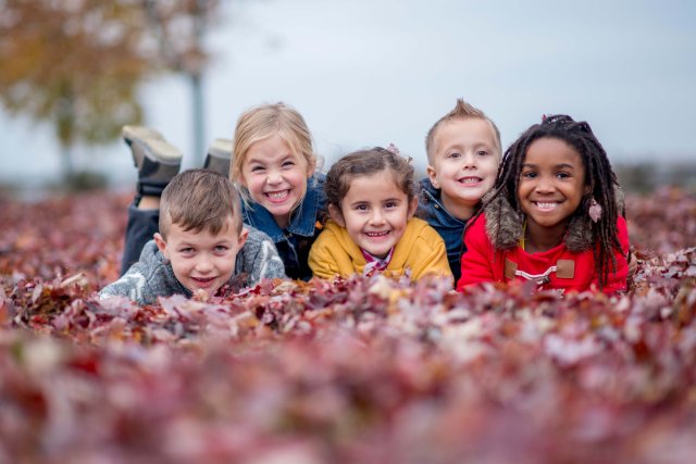 A group of kids playing in leaves