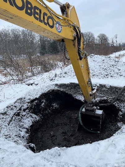 Large machinery excavating the snow covered ground