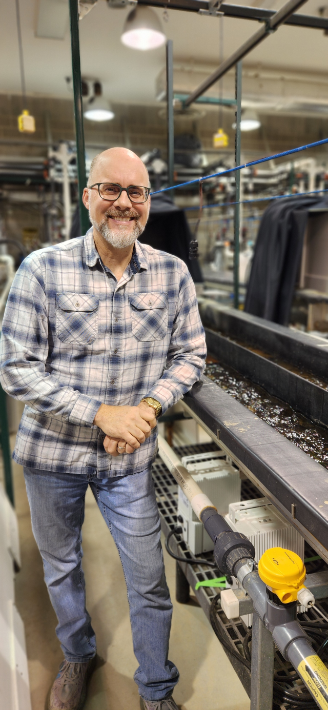 EPA researcher Chris Neitsch posing smiling for the camera while working in a lab