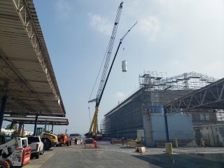 Image of a mobile crane lowering stack to landing pad.