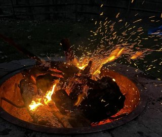 Sparks fly from a wood burning fire.