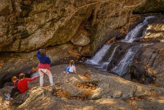 Family sitting outside by a waterfall