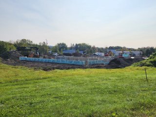 A new construction site with work vehicles in the background and building foundation in the foreground