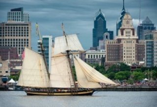 A tall ship on the Delaware River against the backdrop of Penn's Landing, Philadelphia, PA. 