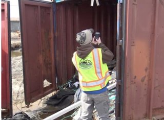 Backhaul Alaska coordinator assisting local village Backhaul team to inventory waste in a shipping container